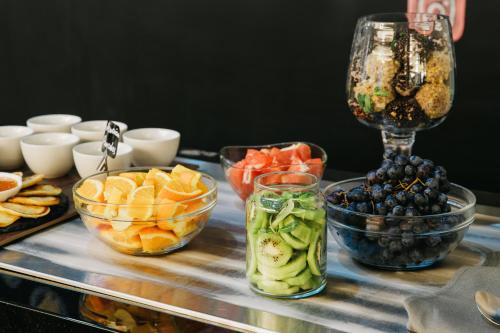 a table topped with bowls of fruit and a wine glass at President Hotel by Hrazdan Hotel CJSC in Yerevan