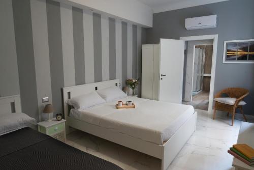 a bedroom with a large white bed and striped walls at Sun Frediano Suites Florence in Florence