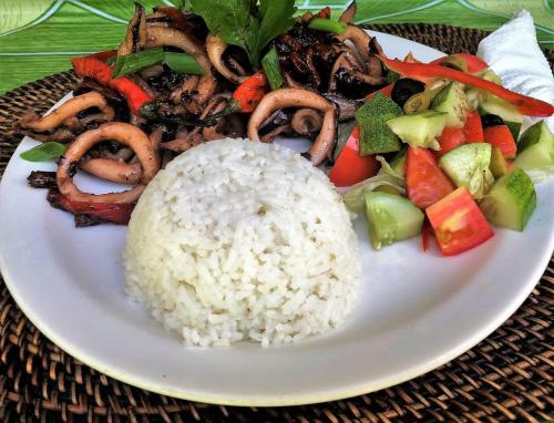 a plate of food with rice and vegetables on a table at White Beach Front and Cottages in Buruanga