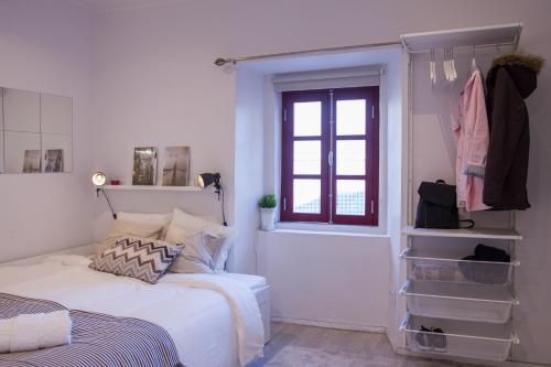 リスボンにあるCasa com Graça - Fully equiped Studio in the Historical Centerの白いベッドルーム(ベッド1台、窓付)