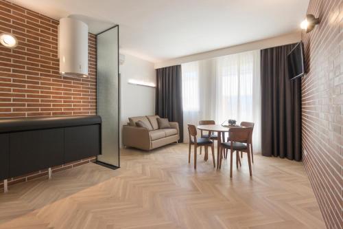 uma sala de estar com uma mesa e cadeiras e um sofá em Metropolitan Suites em Ancona