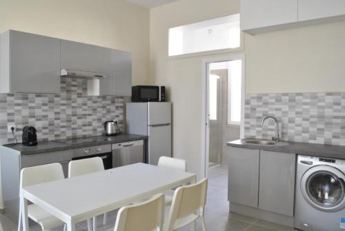 - une cuisine avec une table blanche, un évier et un lave-linge dans l'établissement Lecerf 2P ZEI5517, à Cannes