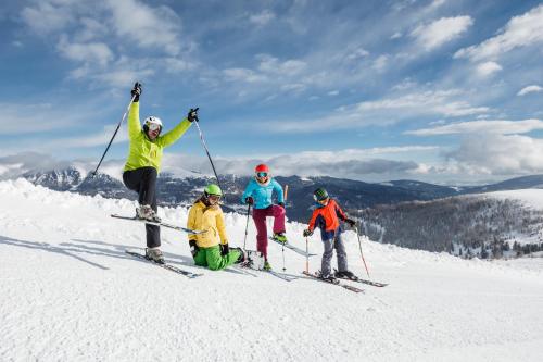 a group of four people on a ski slope at Heidi-Hotel Falkertsee - Kinderhotel in Patergassen