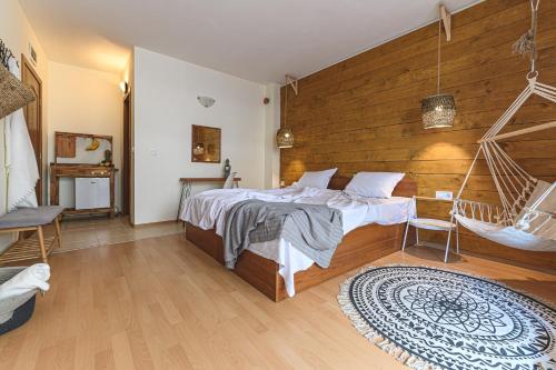 a bedroom with a bed and a wooden wall at The Monkee Studios in Sveti Vlas