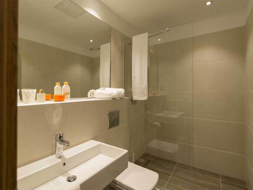 a bathroom with a sink and a toilet and a shower at Motel Plus Berlin in Berlin