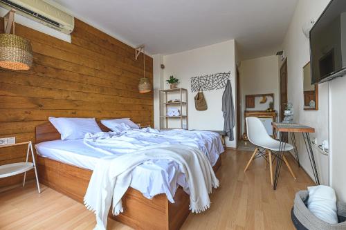 a bedroom with a large bed with a wooden wall at The Monkee Studios in Sveti Vlas