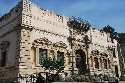 a large white building with a tree in front of it at Three Rooms in Messina