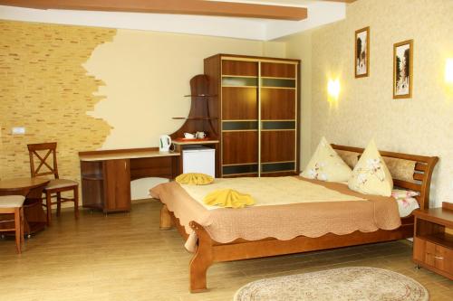 a bedroom with a bed and a table and a desk at Kvasova Voda in Polyana