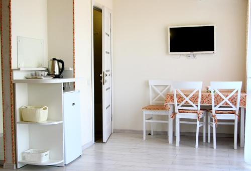 a room with a table and two chairs and a tv at Kvasova Voda in Polyana