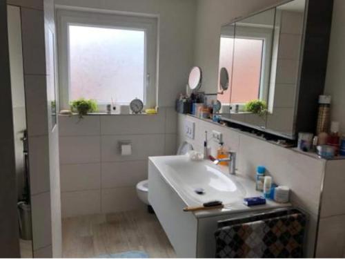 een badkamer met een wastafel, een toilet en een spiegel bij Gasthof ´s Gräbele in Tübingen