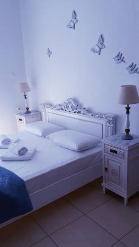 a bedroom with a large white bed and a nightstand at Christos Rooms in Palaiochóra