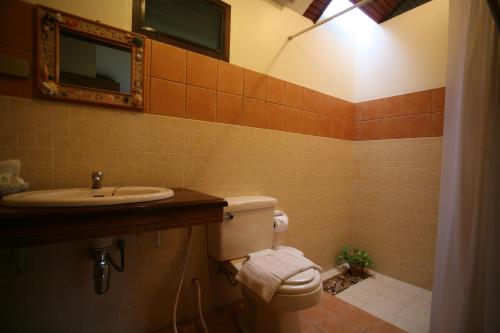 a bathroom with a toilet and a sink and a mirror at Suan Bankrut Beach Resort in Ban Krut