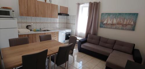 a kitchen and dining room with a table and a couch at Family House Nerezine in Nerezine