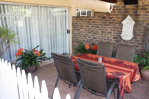 a patio with a table and chairs and a white fence at Little Umhlanga in Pretoria