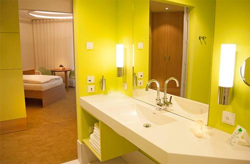 a bathroom with a sink and a yellow wall at TraumHaus im Elsterpark in Herzberg