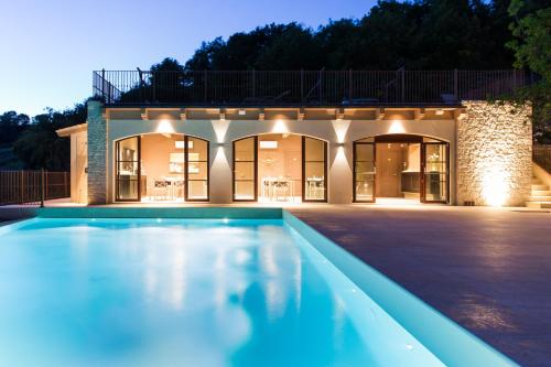 a swimming pool in front of a house at night at Agriturismo Fattoria di Monticello in San Venanzo