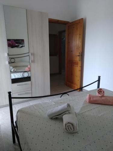 a bedroom with a bed with a mirror on it at Budoni Apartments in Budoni