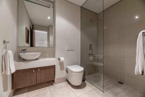 a bathroom with a sink and a toilet and a shower at 706 Canal Quays in Cape Town