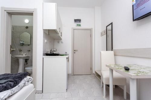 a white bathroom with a sink and a toilet at Vila Ćirković - U centru Sokobanje in Soko Banja
