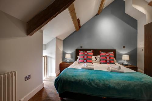 a bedroom with a large bed with red pillows at The Cottage Llyn Peninsula in Nefyn