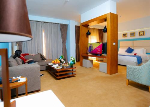 a living room with a bed and a living room with a couch at Tolip Family Park Hotel in Cairo