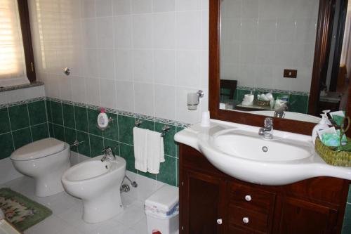 a bathroom with a sink and a toilet and a mirror at Villa Orlando in Bova Marina
