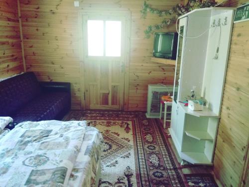 Habitación con cama, sofá y ventana en Kapuzbaşı Şelalesi Baştürk dinlenme tesisleri en Büyükçakır