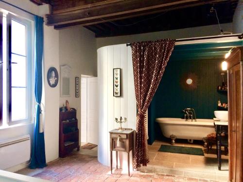 une salle de bain avec une baignoire et un lavabo dans l'établissement Le Boudoir d'artiste, à Semur-en-Auxois