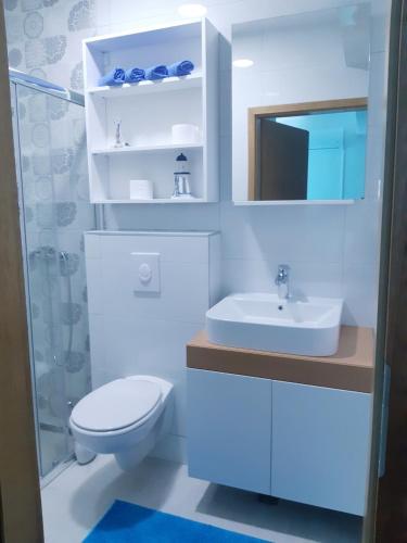 a white bathroom with a toilet and a sink at Villa Star in Drvenik