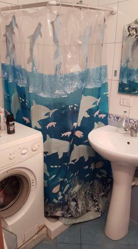 a bathroom with a shark shower curtain and a sink at Bonbon Sea Apartment in Orikum