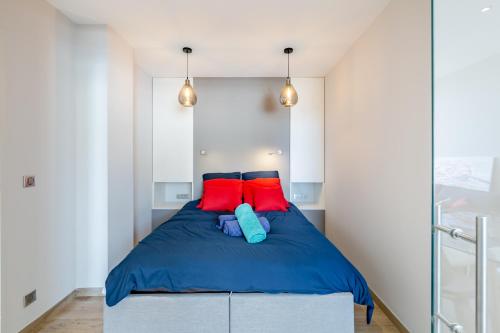 a bedroom with a bed with red and blue pillows at Le Bel Ecrin par Dodo-a-Cassis in Cassis