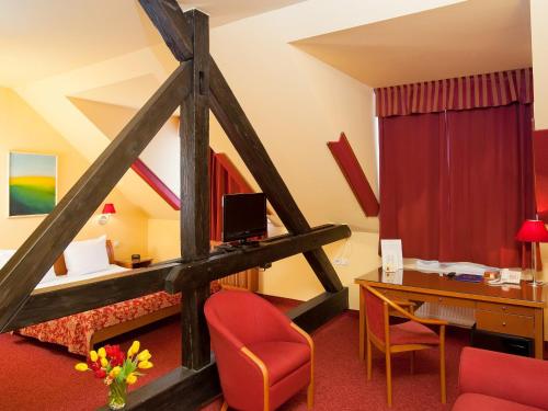 プラハにあるクロイスター イン ホテルのベッドとデスクが備わるホテルルームです。