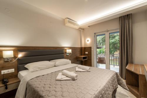 1 dormitorio con 1 cama grande y toallas. en Sintrivanis Resort Beach, en Paralía Skotínis
