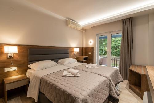 1 dormitorio con 1 cama con 2 toallas en Sintrivanis Resort Beach, en Paralía Skotínis