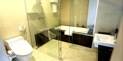 a bathroom with a shower and a toilet and a sink at Inje Speedium Hotel & Resort in Inje