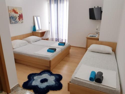 - une petite chambre avec 2 lits et une télévision dans l'établissement Villa Star, à Drvenik