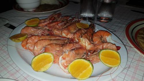 a plate of food with shrimp and lemons on a table at Juani beach bungalows in Kilindoni