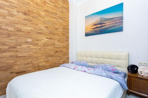 1 dormitorio con 1 cama y pared de madera en NEW Spa Centrе Apartments Kirova en Minsk