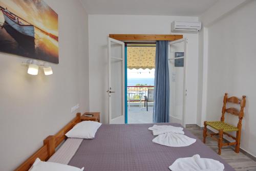a bedroom with a bed and a chair and a window at Αlexandros apartment in Votsi
