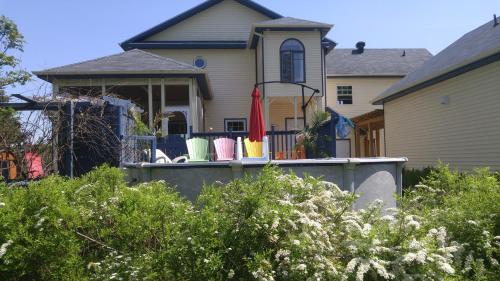 a house with a porch with chairs on it at Domaine de la Baie, Les Suites in Shawinigan