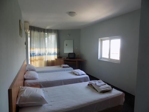 a room with three beds and a window at Hostel Papagal in Varna City