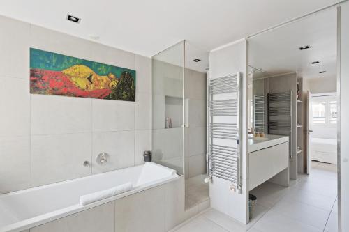 une salle de bain blanche avec une baignoire et un lavabo dans l'établissement Veeve - Grenelle Aspect, à Paris