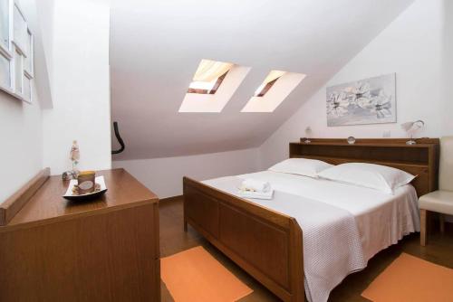 1 dormitorio con 1 cama y tragaluz en APARTMAN MILETIĆ en Makarska