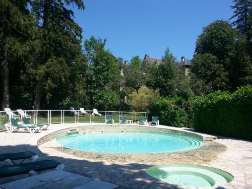 una piccola piscina con sedie e tavolo di Chateau d'Ayres - Hôtel & Spa a Meyrueis