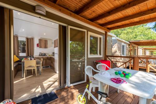 un porche cubierto con mesa y sillas en Camping Village Il Poggetto en Troghi