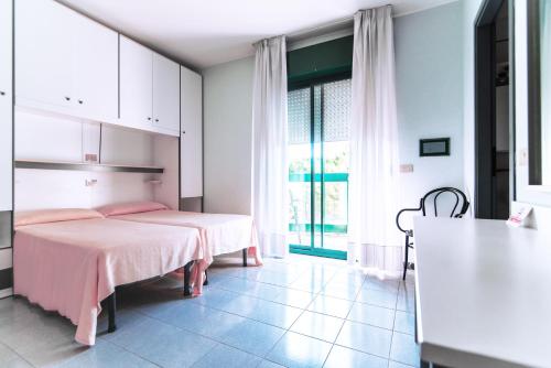a bedroom with a pink bed and a large window at New Tiffany's Park in Lido di Jesolo