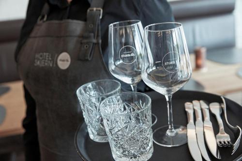 a person holding a tray with wine glasses on it at Hotel Skjern in Skjern