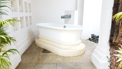 a bathroom with a bath tub in the corner at Taj Bekal Resort & Spa, Kerala in Bekal
