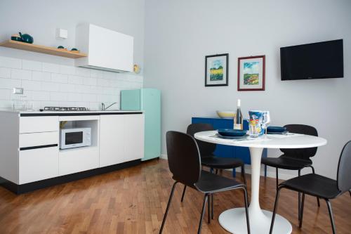 a kitchen and dining room with a table and chairs at Laurus apartments in Trapani