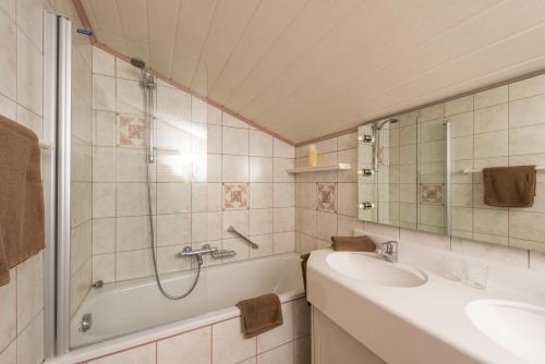 a bathroom with a tub and a sink and a shower at Appartementhaus Christophorus in Obertauern